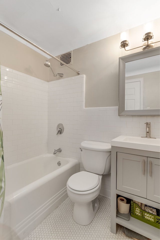 full bathroom with vanity, tile patterned floors, tile walls, and tiled shower / bath combo