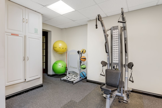 workout room featuring a drop ceiling and dark colored carpet