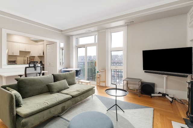 living room featuring ornamental molding and light parquet flooring