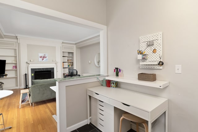 interior space featuring a fireplace, hardwood / wood-style floors, and built in shelves