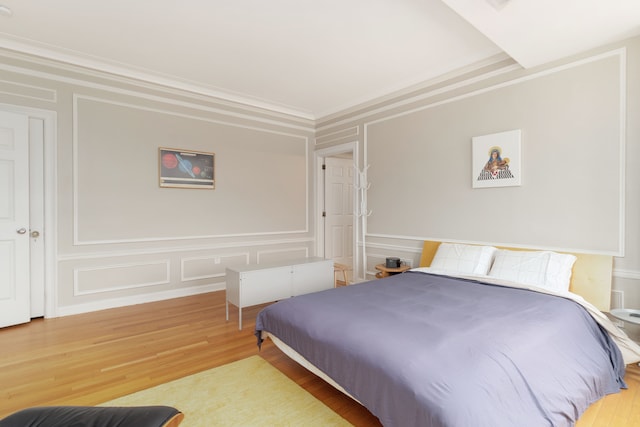 bedroom with light hardwood / wood-style flooring and crown molding