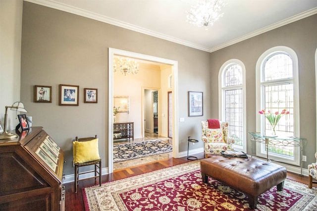 living area with crown molding, hardwood / wood-style floors, and a notable chandelier