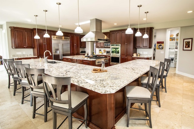 kitchen featuring decorative light fixtures, island exhaust hood, a large island, a breakfast bar area, and stainless steel appliances