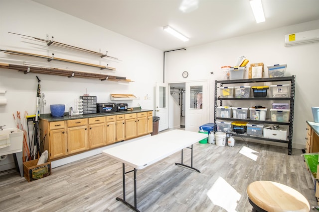 kitchen featuring an AC wall unit, light hardwood / wood-style flooring, and sink