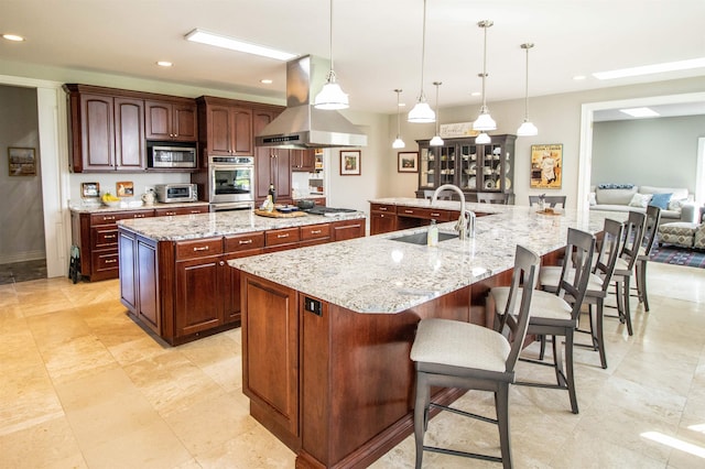 kitchen with pendant lighting, a spacious island, sink, appliances with stainless steel finishes, and island range hood