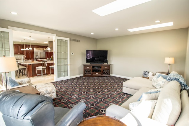 living room featuring a skylight and light carpet