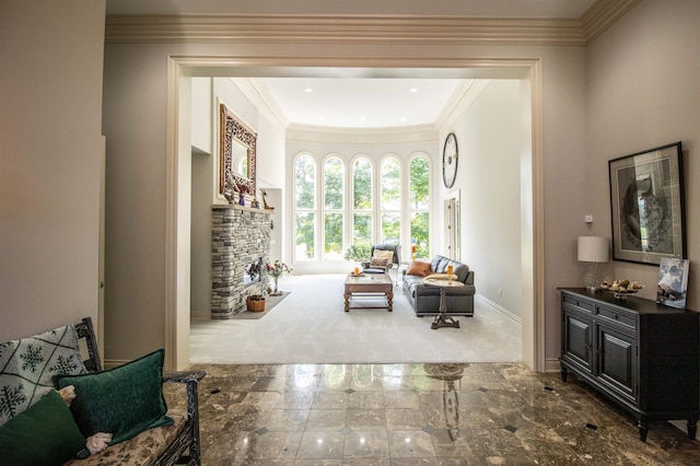 sitting room featuring a stone fireplace, dark colored carpet, and ornamental molding