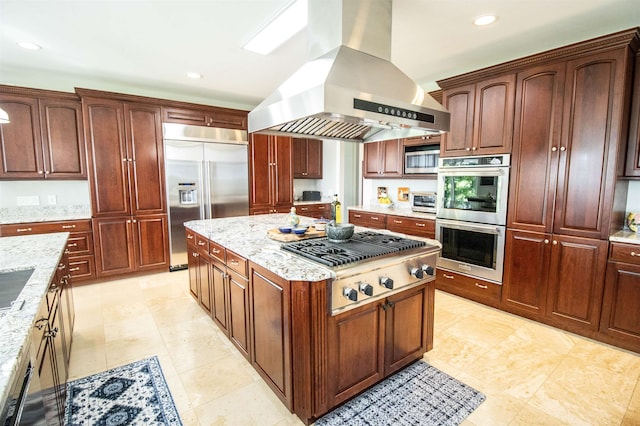 kitchen featuring light stone counters, light tile patterned floors, island exhaust hood, and stainless steel appliances