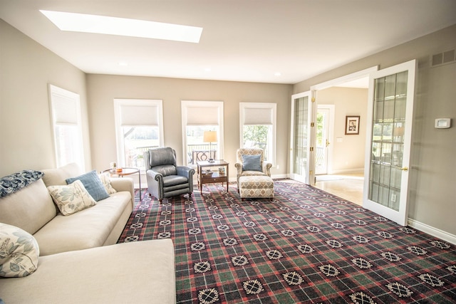 living room with carpet floors, french doors, and a skylight