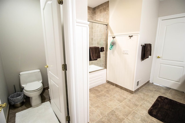 bathroom featuring bath / shower combo with glass door and toilet