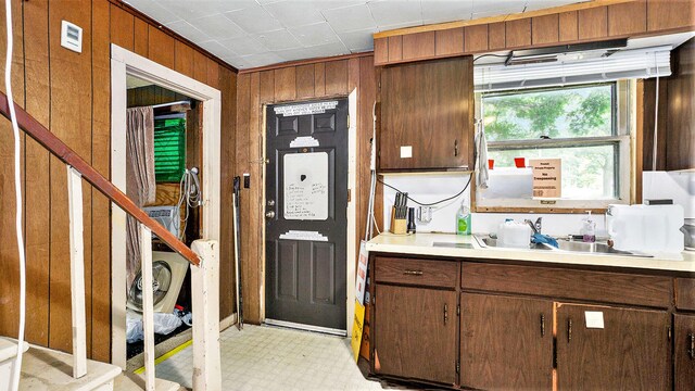 kitchen featuring sink and wooden walls