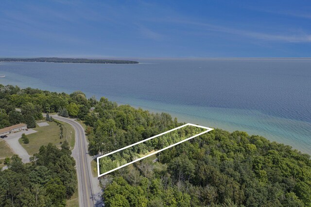 2788 N W Bay Shore Dr, Suttons Bay, MI 49682 - aerial view of property and surrounding area featuring property boundaries highlighted, a large body of water, and a heavily wooded area