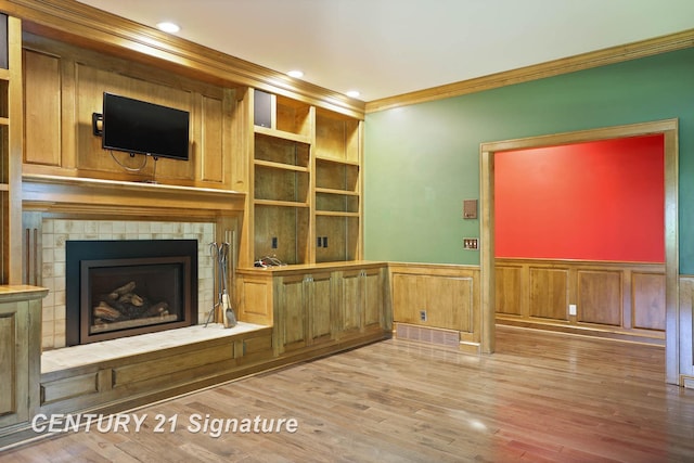 unfurnished living room with wood-type flooring and ornamental molding