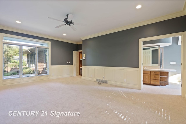 empty room featuring ceiling fan, light colored carpet, and ornamental molding