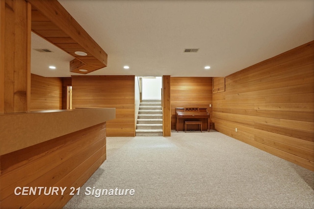 interior space featuring carpet flooring and wood walls