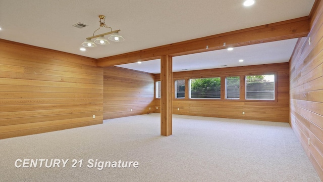 empty room featuring wooden walls and light carpet