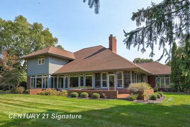 back of house featuring a sunroom and a lawn