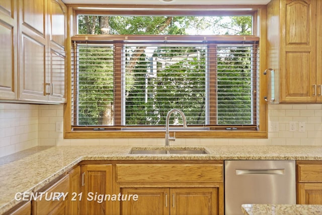 kitchen with dishwasher, backsplash, light stone countertops, and sink