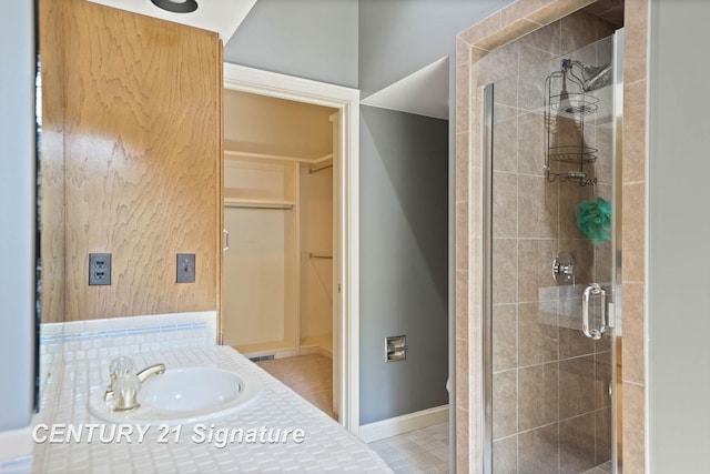 bathroom featuring tile patterned floors, an enclosed shower, and sink