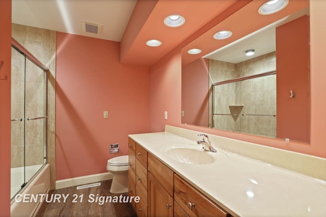 full bathroom with shower / bath combination with glass door, vanity, wood-type flooring, and toilet