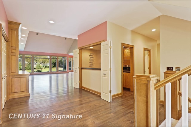 corridor with dark hardwood / wood-style floors and vaulted ceiling