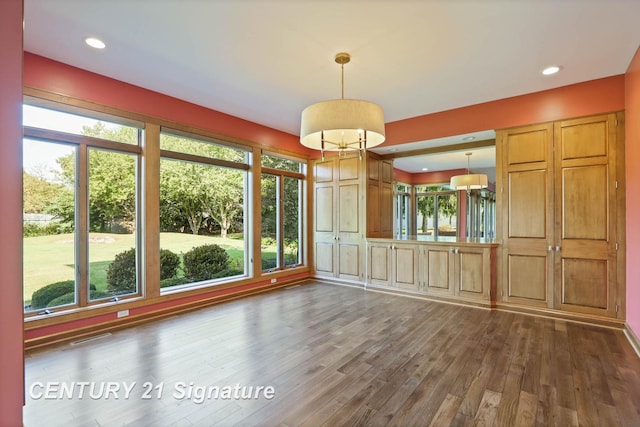 unfurnished dining area featuring dark hardwood / wood-style flooring and a wealth of natural light