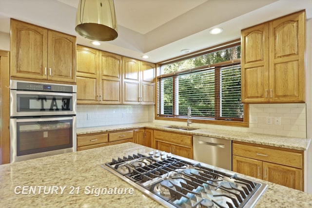 kitchen with light stone countertops, appliances with stainless steel finishes, tasteful backsplash, and sink