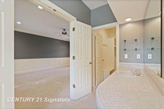 interior space with light colored carpet, ornamental molding, and sink