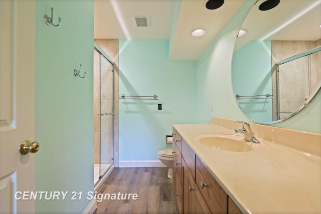 bathroom featuring walk in shower, toilet, vanity, and hardwood / wood-style flooring