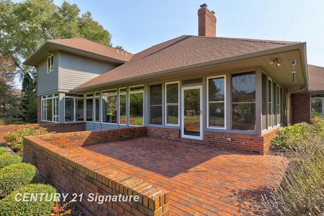 rear view of house with a patio area and a sunroom