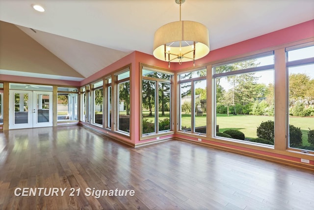 interior space featuring a chandelier, french doors, a healthy amount of sunlight, and vaulted ceiling