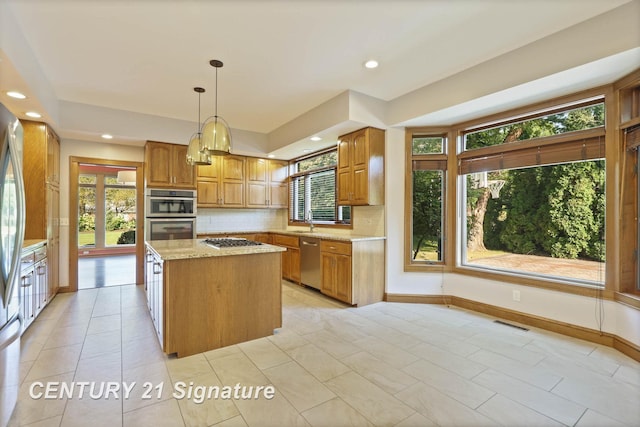 kitchen with appliances with stainless steel finishes, a center island, and a wealth of natural light