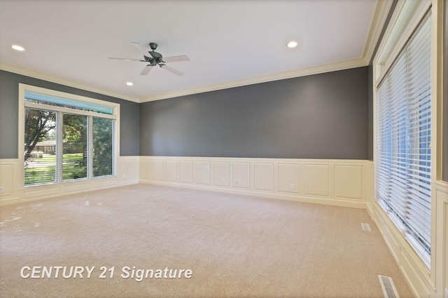 carpeted empty room featuring ceiling fan and crown molding