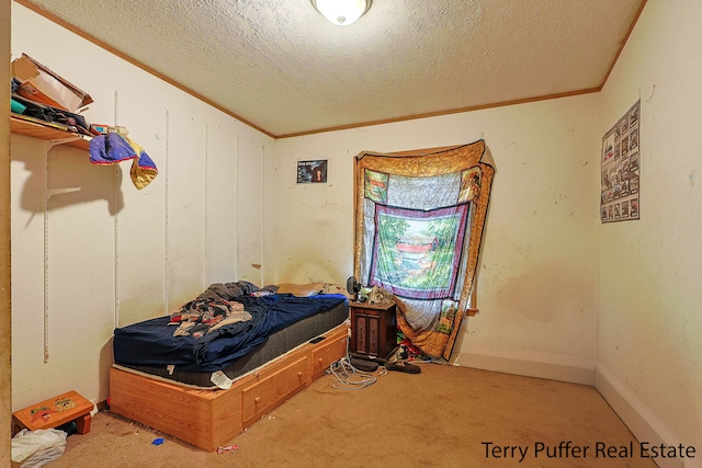 bedroom featuring carpet, a textured ceiling, and ornamental molding