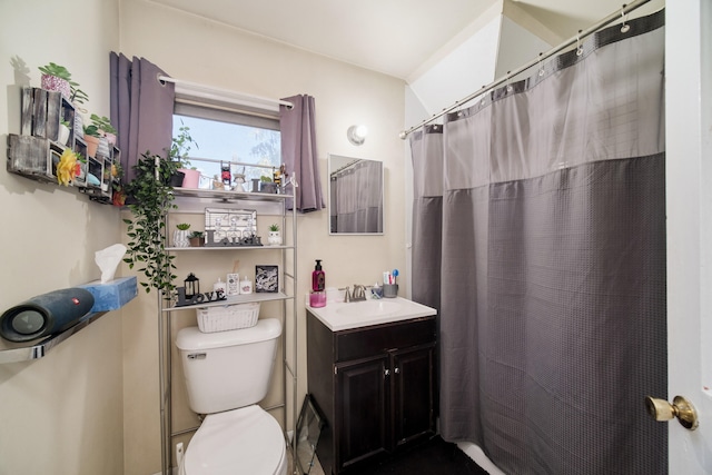 bathroom with curtained shower, vanity, and toilet