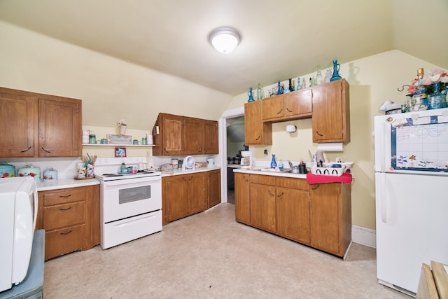 kitchen featuring white appliances, light carpet, and vaulted ceiling