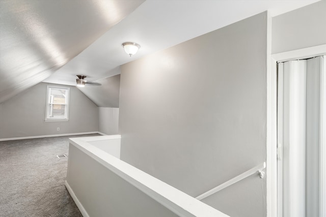 corridor featuring carpet flooring and lofted ceiling