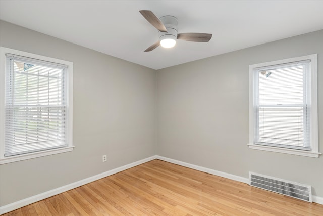 empty room with ceiling fan and light hardwood / wood-style flooring