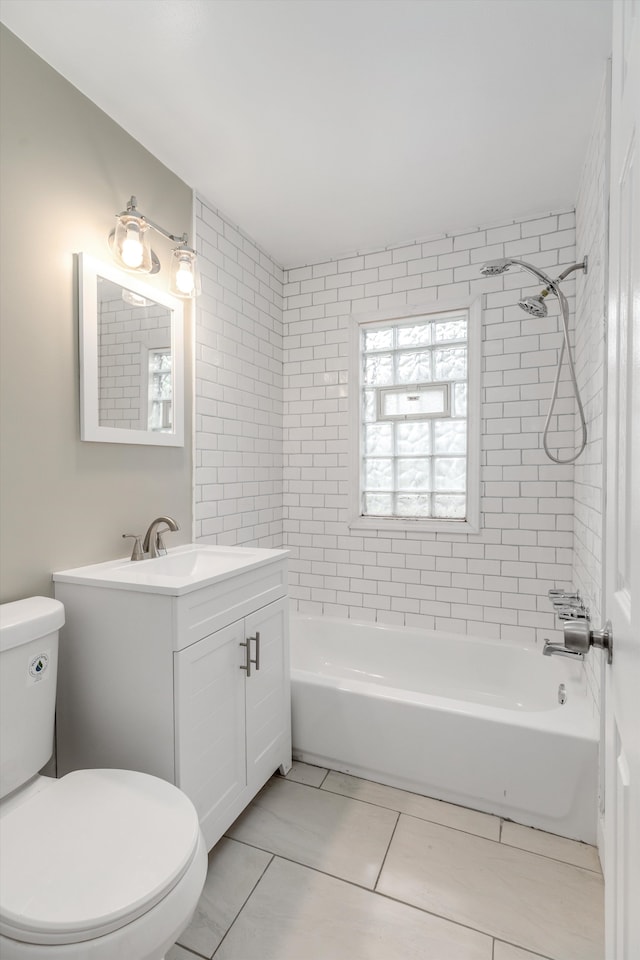 full bathroom featuring tile patterned flooring, vanity, tiled shower / bath combo, and toilet