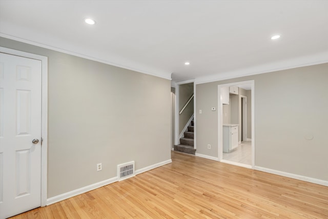 empty room with light hardwood / wood-style flooring and ornamental molding