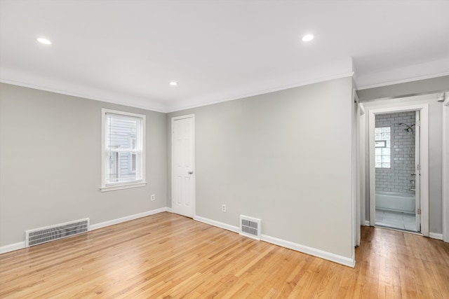 empty room featuring crown molding and light hardwood / wood-style flooring