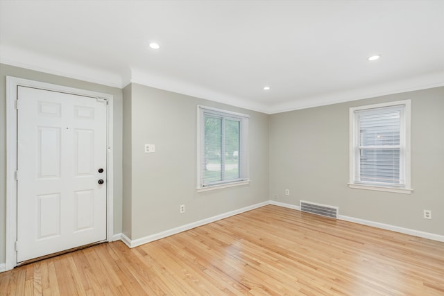 entryway with light wood-type flooring and crown molding