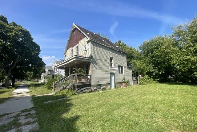 view of side of property featuring a porch and a yard