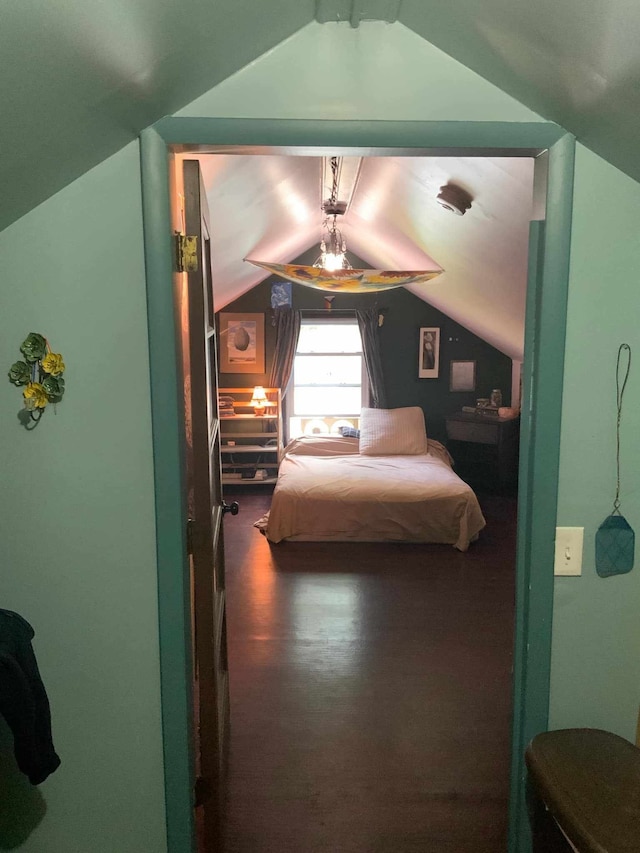 bedroom with ceiling fan, dark wood-type flooring, and vaulted ceiling