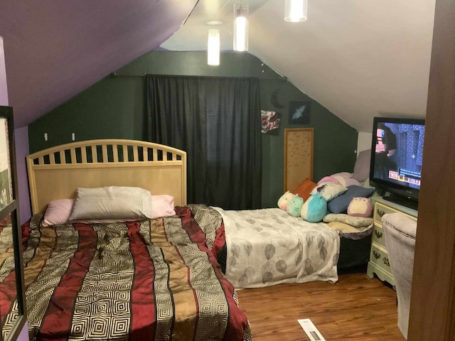 bedroom with wood-type flooring and vaulted ceiling