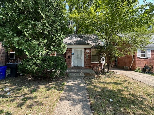 18538 Trinity St, Detroit, MI 48219 - view of property hidden behind natural elements featuring brick siding and a front yard