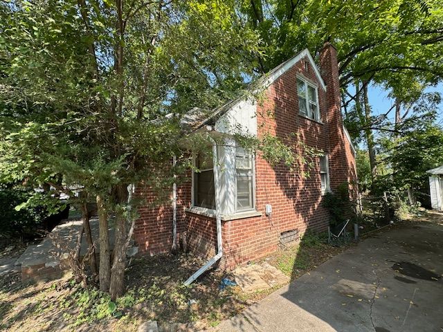 18538 Trinity St, Detroit, MI 48219 - view of home's exterior with a chimney, brick siding, and crawl space