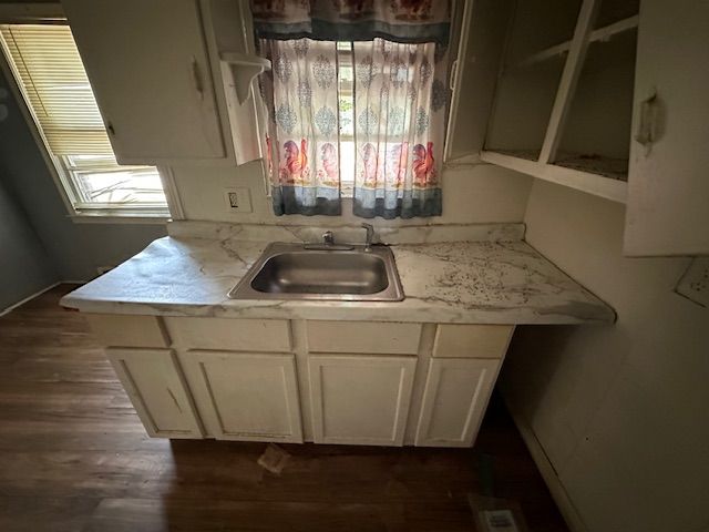 kitchen featuring sink, white cabinets, and dark wood-type flooring