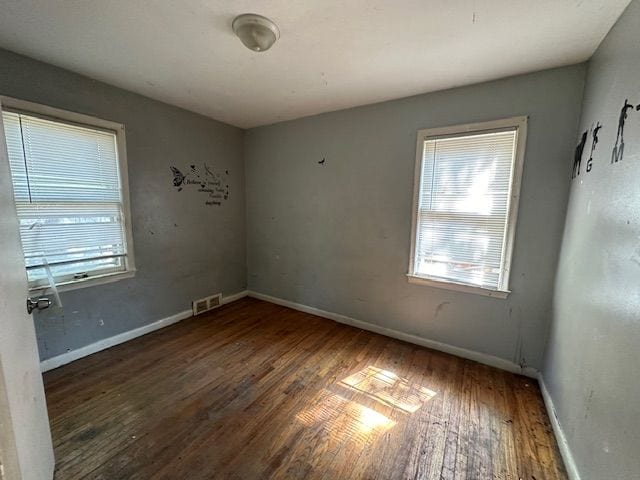 unfurnished room with dark hardwood / wood-style flooring