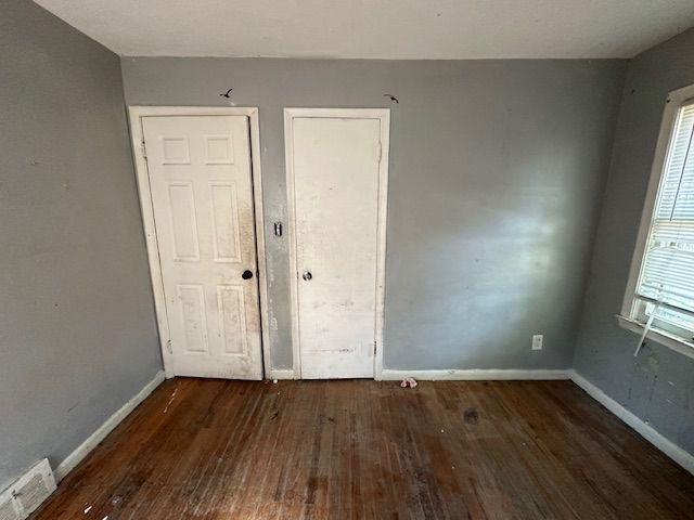 unfurnished room featuring dark wood-type flooring